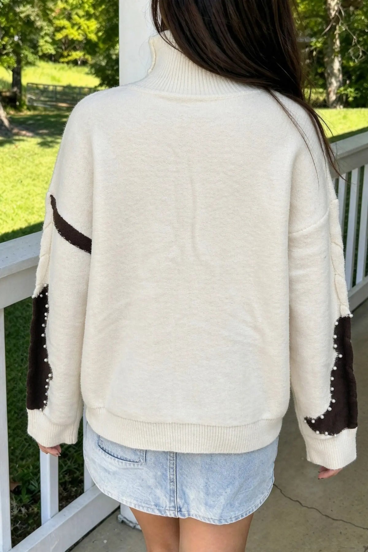 Beige cable knit mock neck sweater with beaded western details