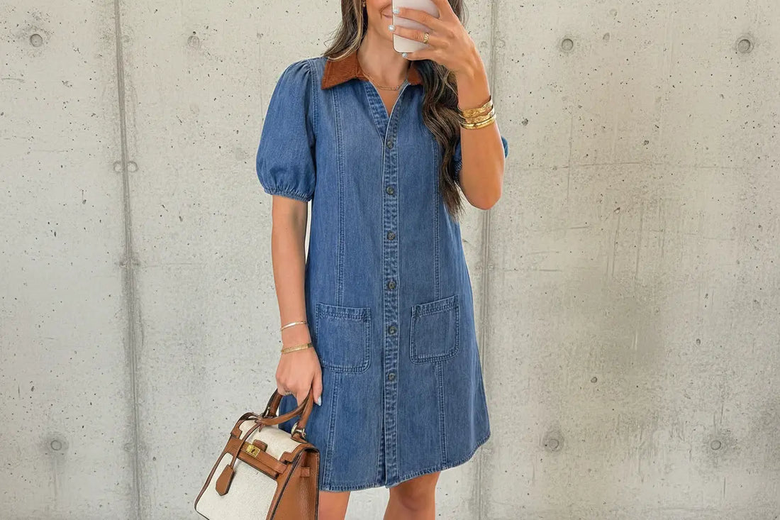 Woman taking a mirror selfie wearing a blue denim dress in a living room.