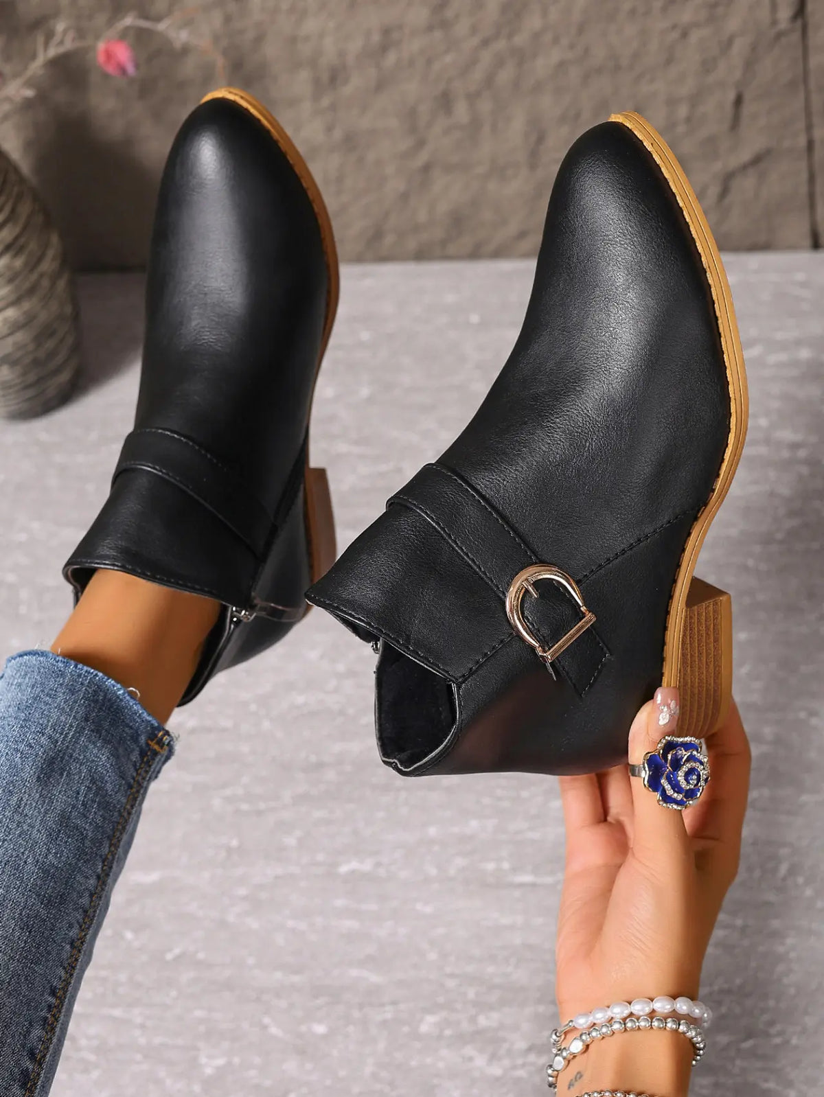 Black buckle ankle boots, hand-held side view